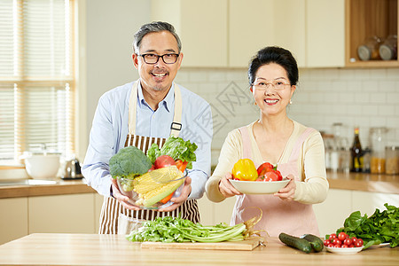 中年夫妇手捧新鲜蔬菜图片