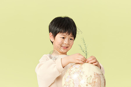 小男孩在地球模型上种了一棵树图片