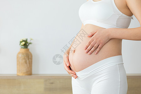居家生活的孕妇摸肚子高清图片