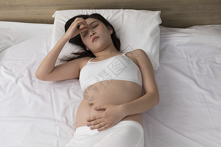 躺在床上头疼的孕妇图片