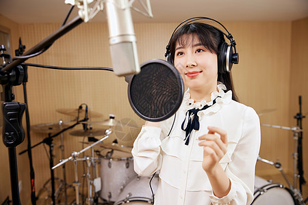 声音工作室录音棚内唱歌的女性背景