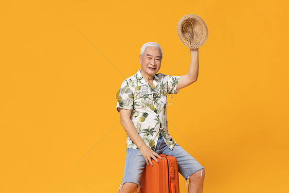 坐在行李箱上的老人旅行图片