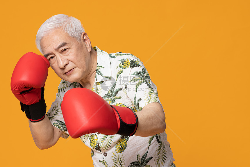 戴着拳击手套练拳的老人
