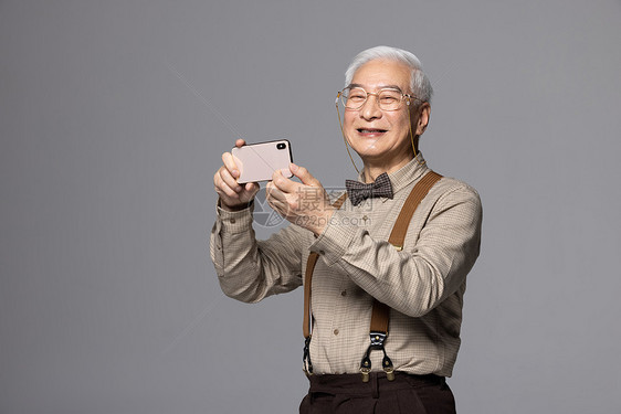 使用手机拍照的老人图片