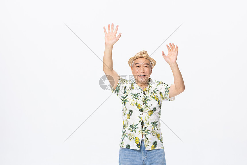 穿着沙滩服旅行的老人双手打招呼图片