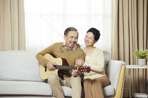快乐的中老年夫妇在客厅弹吉他图片