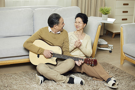 中老年夫妇在客厅弹吉他对视图片
