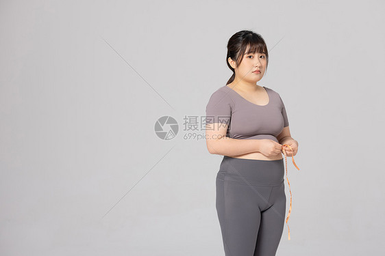 女性使用卷尺测量腰围图片