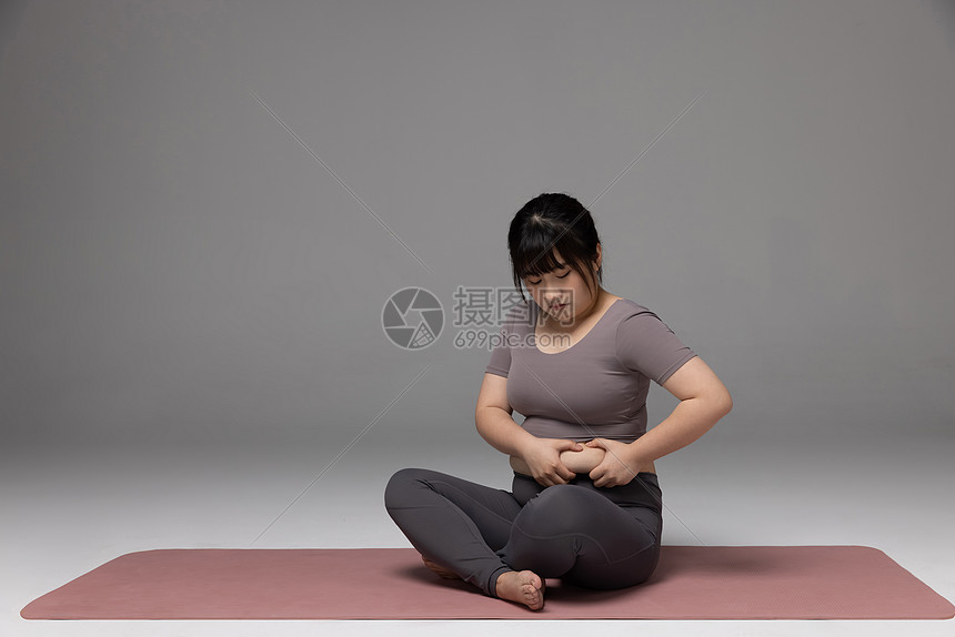 照片 人物情感 肚子疼 肥胖女性捏着自己的肉.