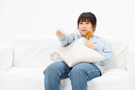 慵懒躺在沙发上看电视的肥胖女性图片