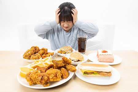 面对食物烦恼的肥胖女性图片