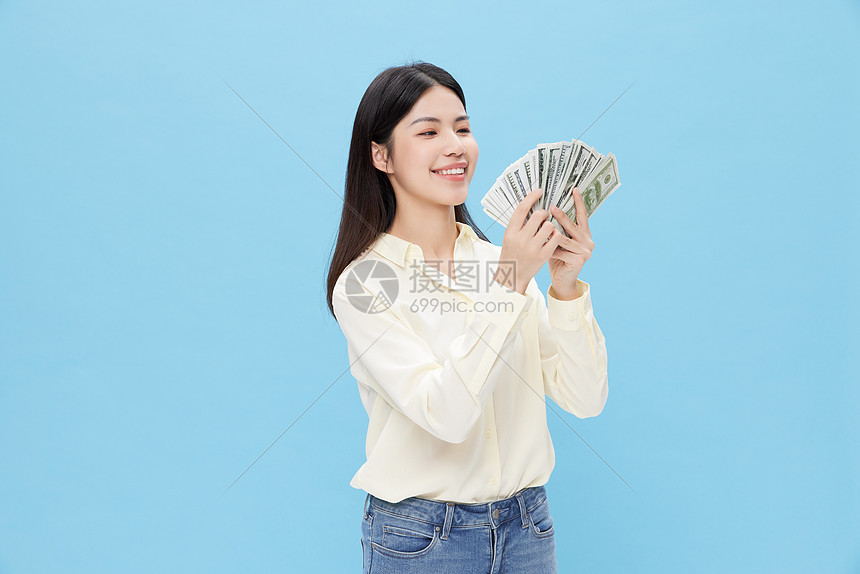 手拿现金的年轻女性图片