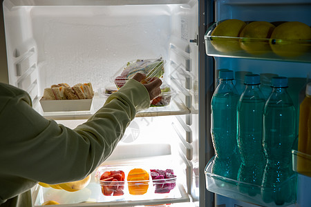 高碳水化合物从冰箱里拿出食物的手背景