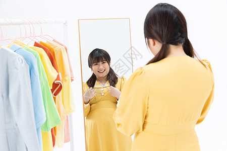 肥胖女性对着镜子挑选服装图片素材
