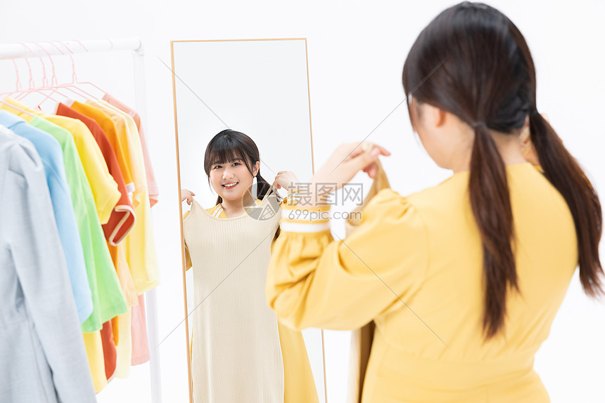 肥胖女性对着镜子挑选服装图片