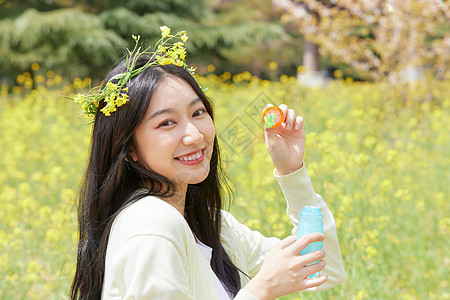 吹泡泡的女孩油菜花花海中的少女吹泡泡背景