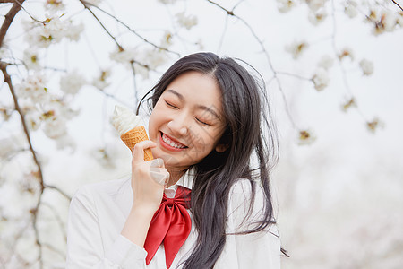 美女吃冰淇淋美女大学生逛游公园吃冰淇淋背景