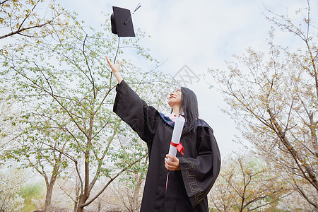 女大学生毕业照女大学生公园花季毕业照扔学士帽背景