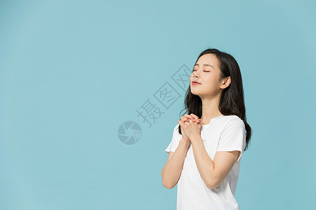 年轻女性闭眼祈祷许愿图片
