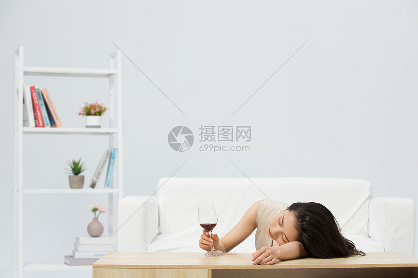 趴在桌子上悲伤难过的女性图片