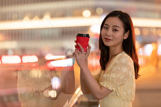 晚上捧着热饮的女性图片