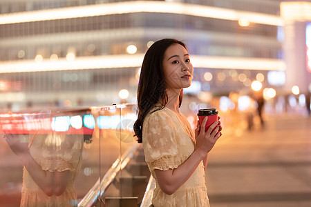 在城市里捧着咖啡的女性图片