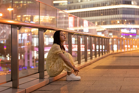 夜晚坐在路边的女性图片