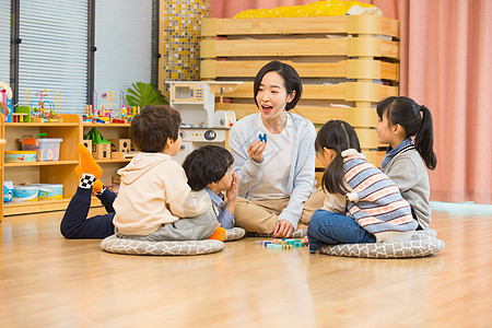 女幼师上课和小朋友们积极互动背景图片