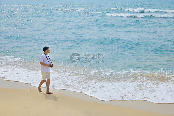年轻男士海边旅行散步图片