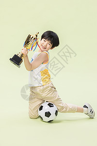 小男孩踢足球得奖杯金牌图片