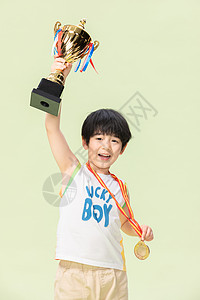 小男孩手捧金牌奖杯图片