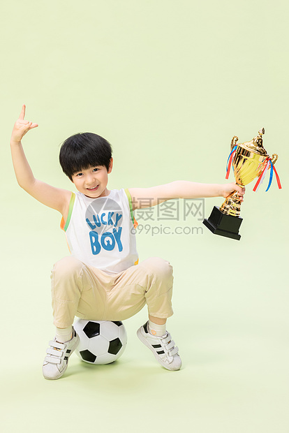 小男孩踢足球得奖杯图片