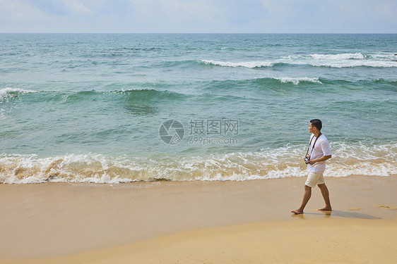 年轻男士海边旅行散步图片