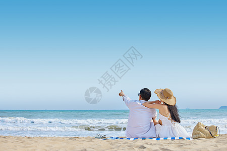 坐在沙滩海边情侣看海背影背景