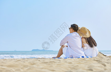 海边情侣坐在沙滩看大海背影高清图片