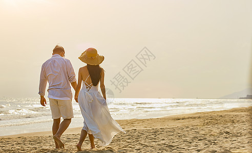 夏季出行旅游傍晚海边情侣散步背影背景
