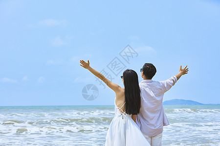 年轻情侣张开手臂拥抱大海高清图片