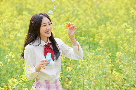 春季油菜花田可爱少女吹泡泡图片