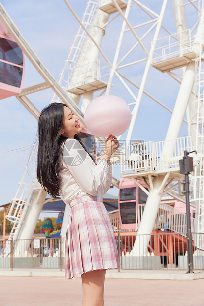 青春可爱美少女拿棉花糖逛游乐园图片