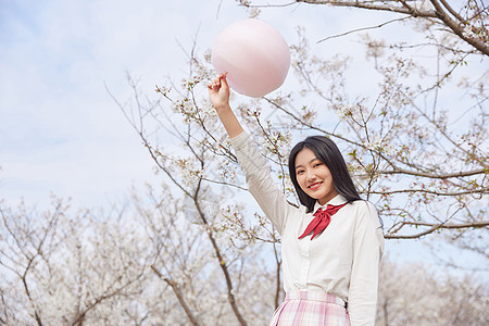 青春可爱美少女拿棉花糖逛游乐园高清图片