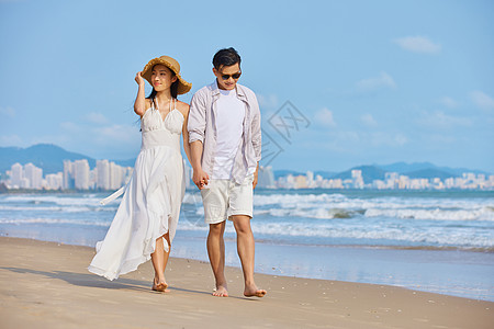 海边美女年轻情侣夏日海边散步背景