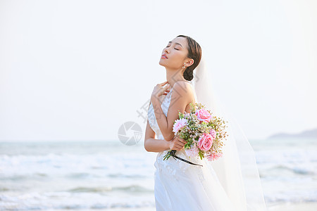 唯美婚纱照海边婚纱美女手拿手捧花背景