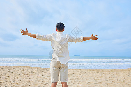男青年张开手臂拥抱大海背影高清图片