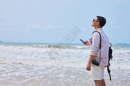 年轻男士海边旅行背影图片