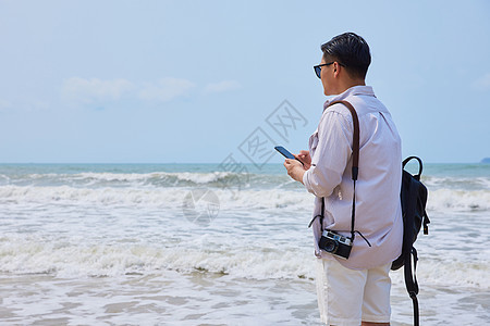 年轻男士海边旅游拍照图片