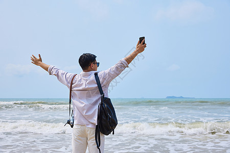 年轻男士海边旅行背影图片