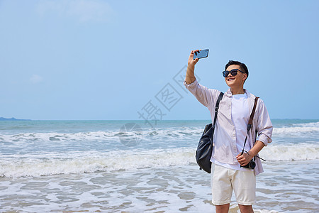 年轻男士海边旅游拍照图片