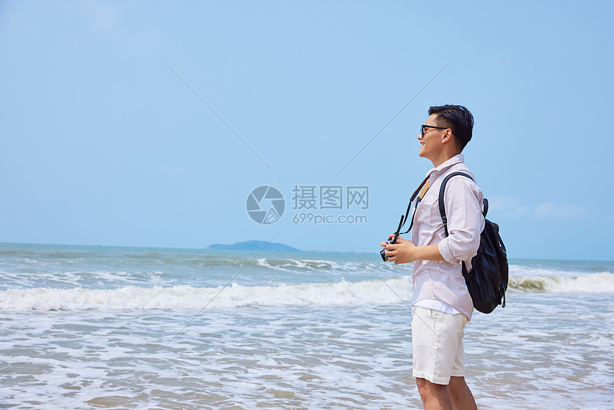 年轻男士海边旅游拍照图片