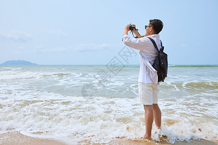 年轻男士海边旅游拍照图片