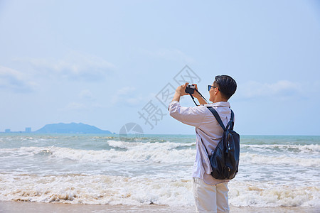 年轻男士海边旅游拍照图片